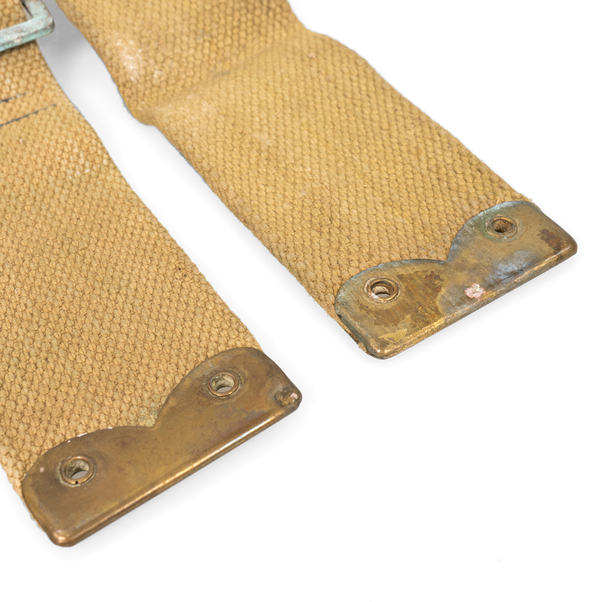 Bottom ends of British Army 37 Pattern L-straps featuring reinforced brass tips with eyelet holes, showing historical signs of use.