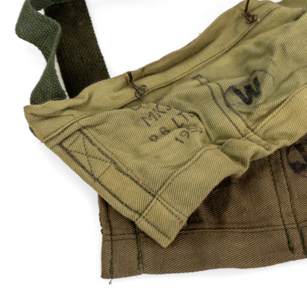 Close-up comparison of two vintage bandoliers showing manufacturing stamps and metal closure hardware details.