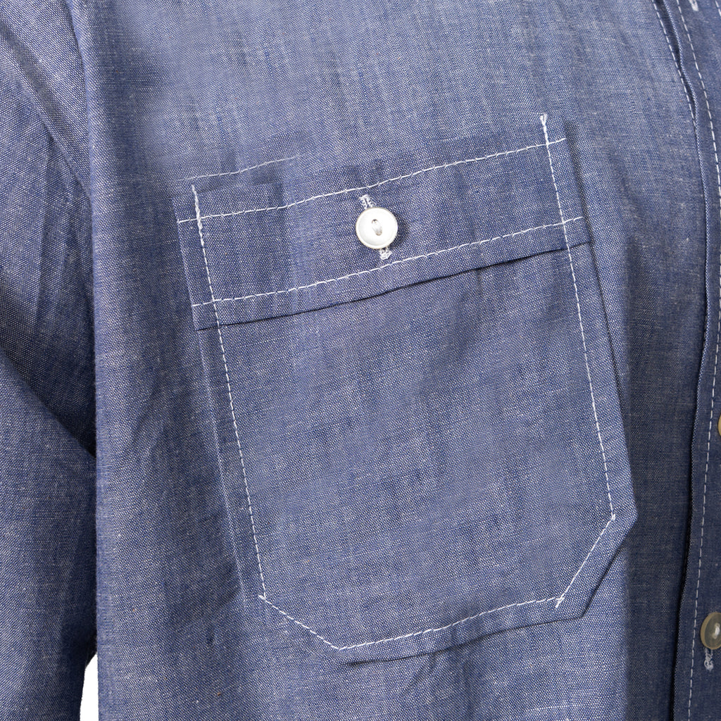 Close-up detail of the buttoned chest pocket on the blue cotton Bundesmarine German Navy shirt, highlighting the high-quality contrasting white stitching.