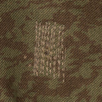 Close-up detail of reinforced repair stitching on the durable cotton-polyester fabric of the vintage Czech M92 field jacket.