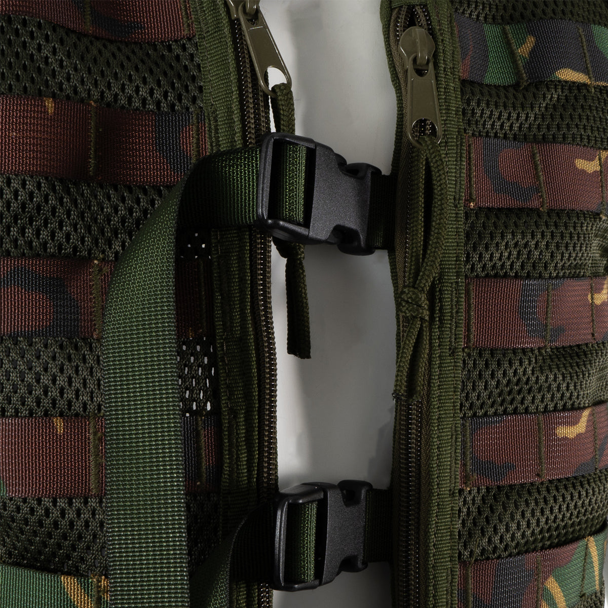 Close-up of the front tactical vest showing durable zipper closures and adjustable plastic buckle straps.