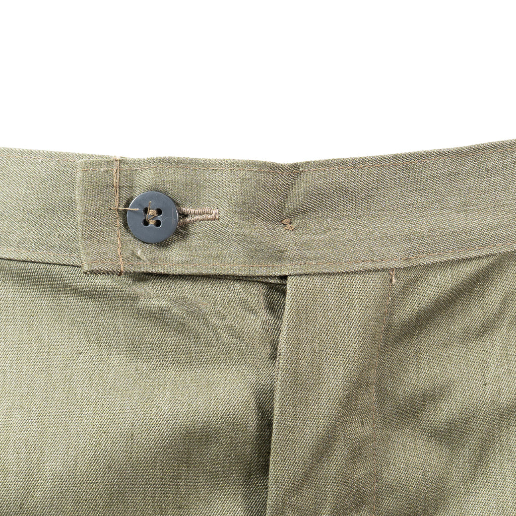 Close-up of the button fly closure and waistband details on original East German NVA military combat field trousers.