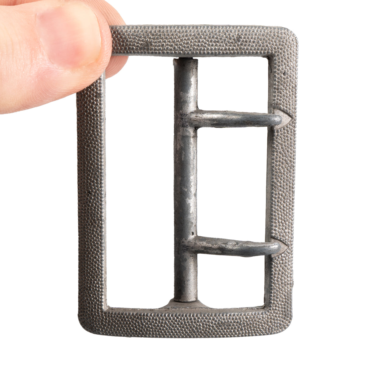 Hand holding the WW2 German Officer's aluminum claw buckle, highlighting the two-prong design and size.