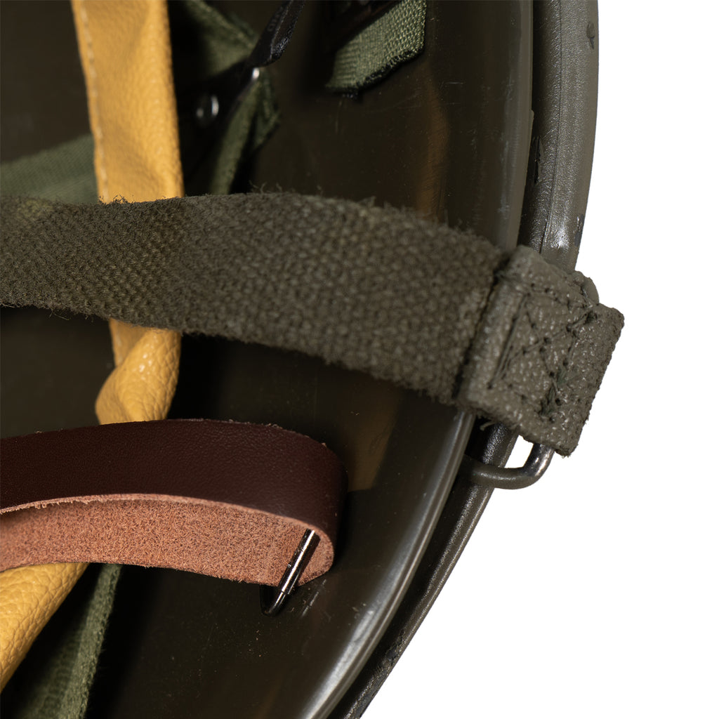 Close-up of the internal helmet liner and retention straps attached to the olive drab shell.