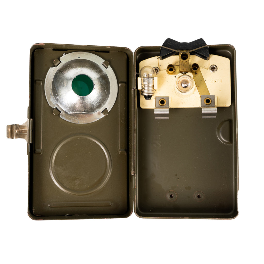 Internal view of a Type 2 Swiss Army military torch revealing the bulb, dimming mechanism, and reflector plate.