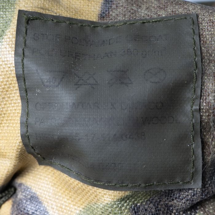 Close-up of the official military label inside the Dutch Army DPM MOLLE pouch with NSN and care instructions.