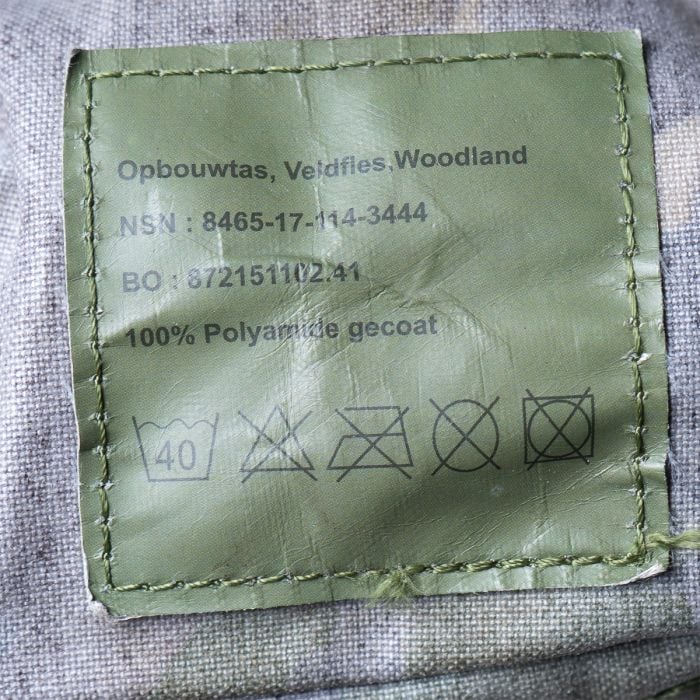 Close-up of military label on Dutch Army water bottle pouch with NSN 8465-17-114-3444 and care instructions