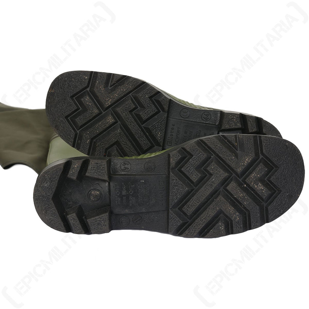 Bottom view of the rubber boot soles showing the deep tread pattern for traction on slippery surfaces.