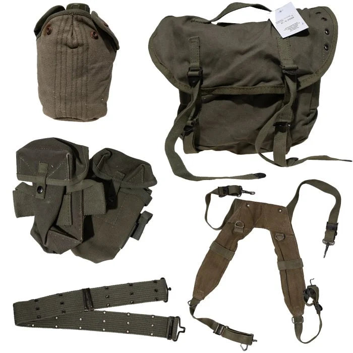 Overhead flat lay of the complete seven piece Greek Army M56 M1971 webbing set with belt, suspenders, pouches, canteen, and field pack