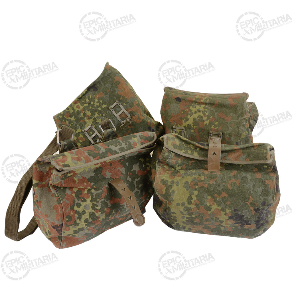 Two German Army Flecktarn roll-top gas mask bags showing their modular attachment clips and durable camouflaged nylon fabric.