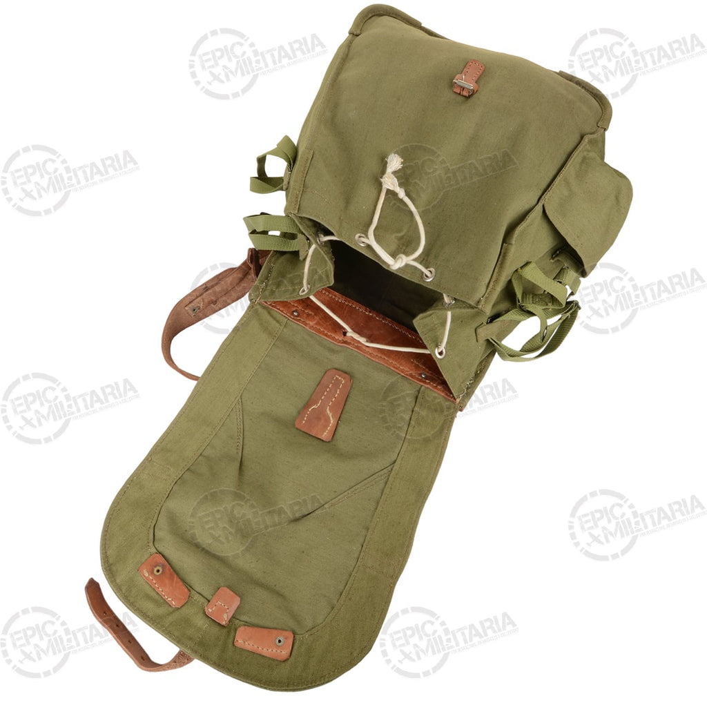 Green backpack with brown leather straps on a white background