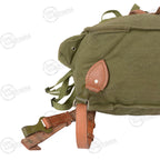 Detailed close-up of the base of the Romanian canvas rucksack showing the leather strap attachment and metal hardware.