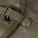 Close-up of the textured olive green strap fastener and button closure on the shovel's protective carrying case.