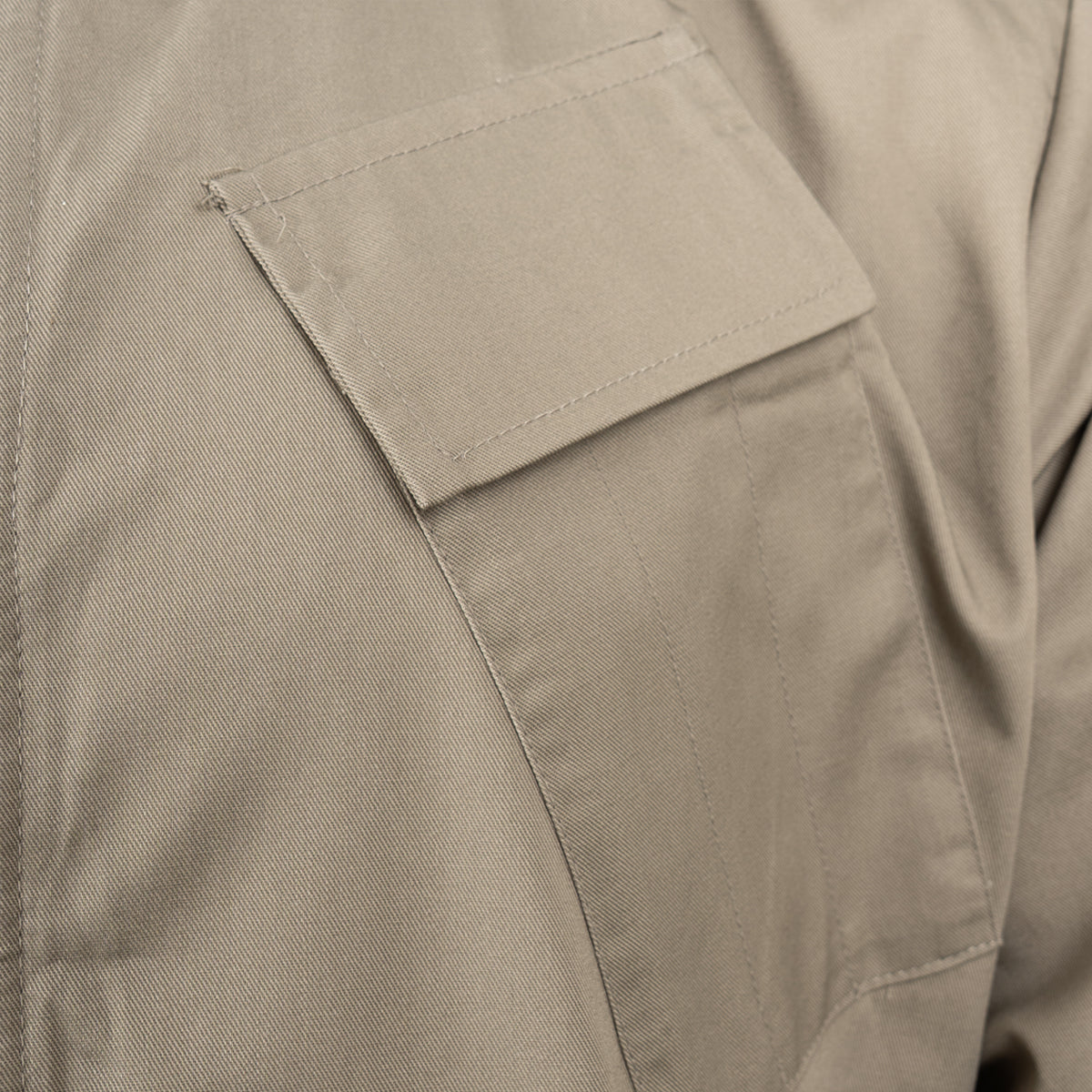 Close-up detail of the angled chest pen pocket on the RAF lightweight coveralls, showing precise stitching and fabric texture.