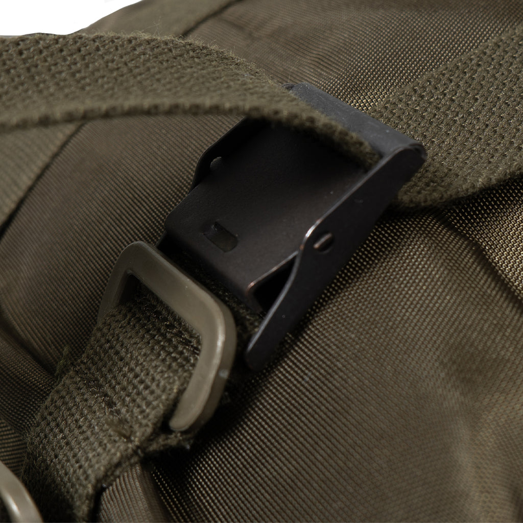 Close-up of a brown bag with a black buckle and strap.