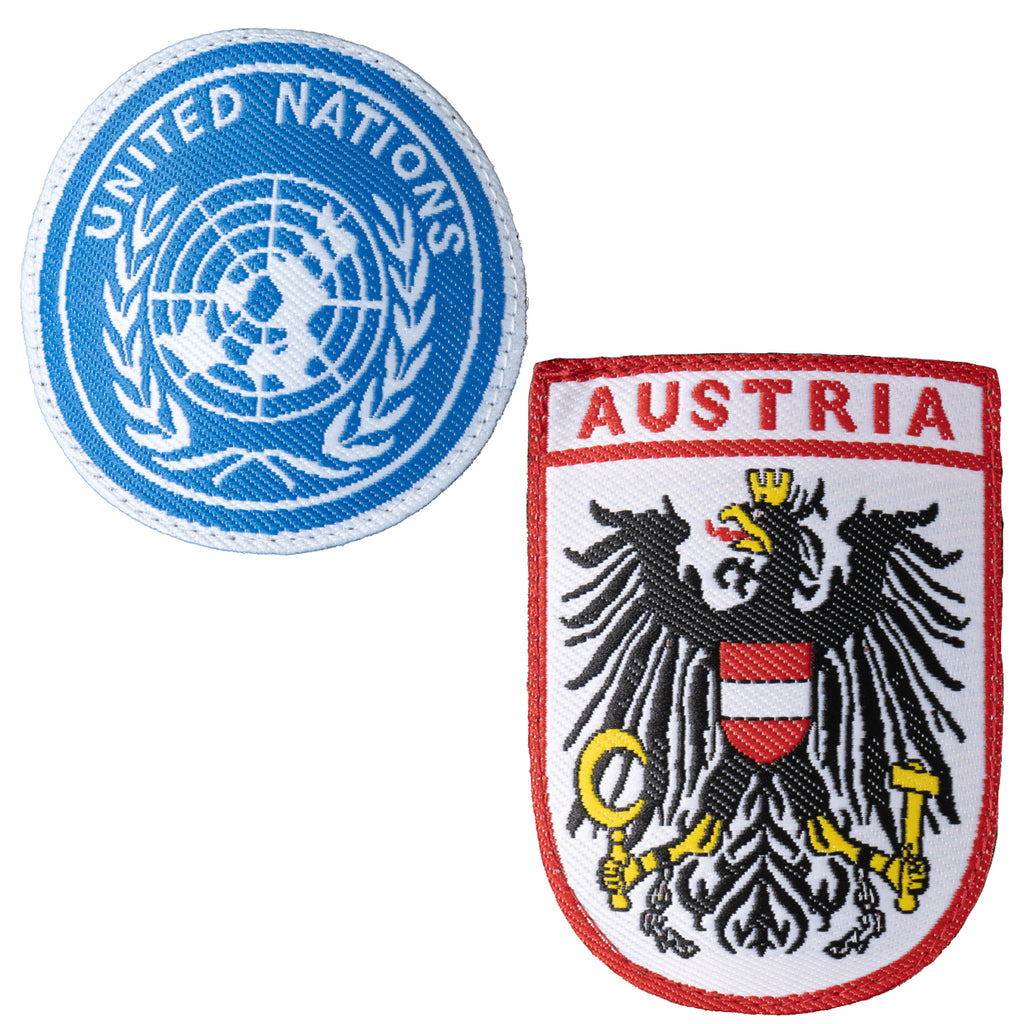 Embroidered patches including the circular blue United Nations insignia and the red-and-white Austrian federal coat of arms.