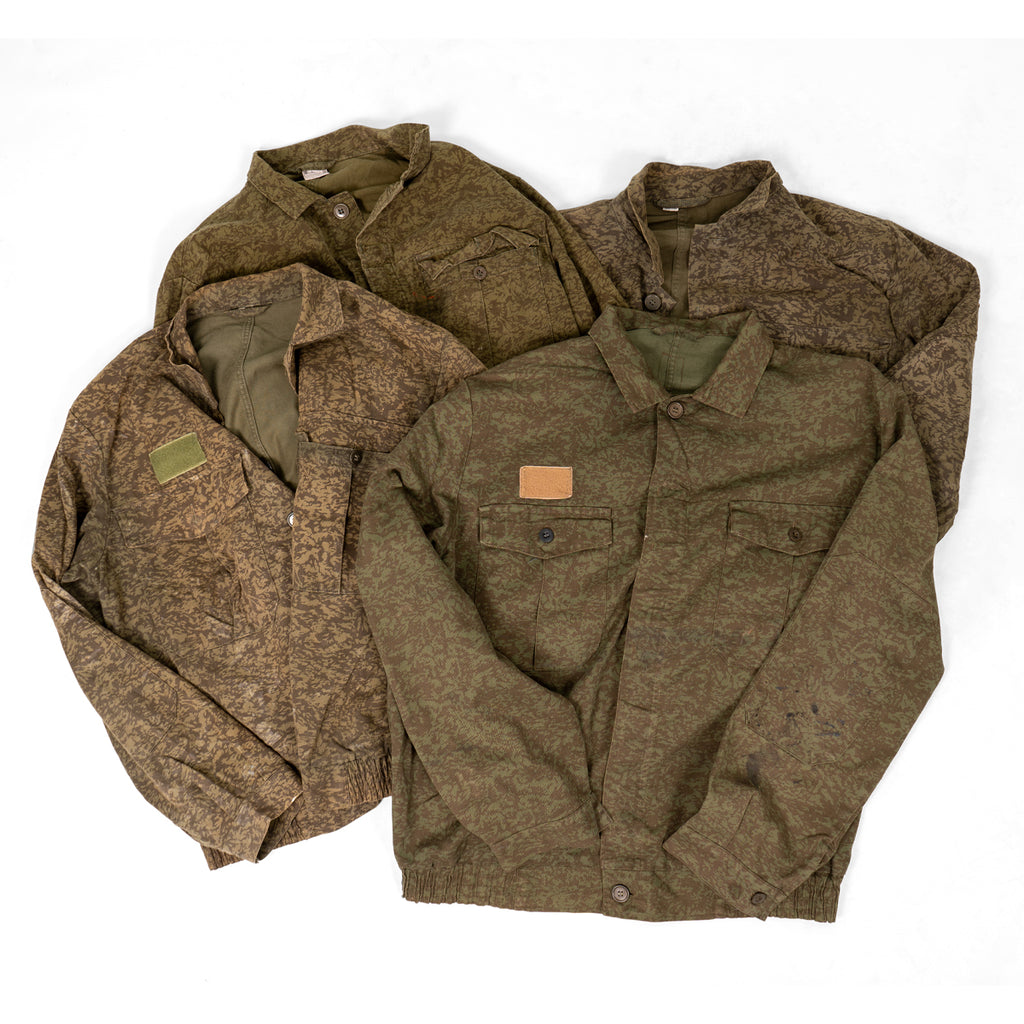 Collection of multiple used-like new Czech Army M92 field jackets showing variations in the vintage camouflage patterns.