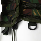 Detail view of the side lacing system with D-ring attachment points on the lower edge of the woodland camo vest.