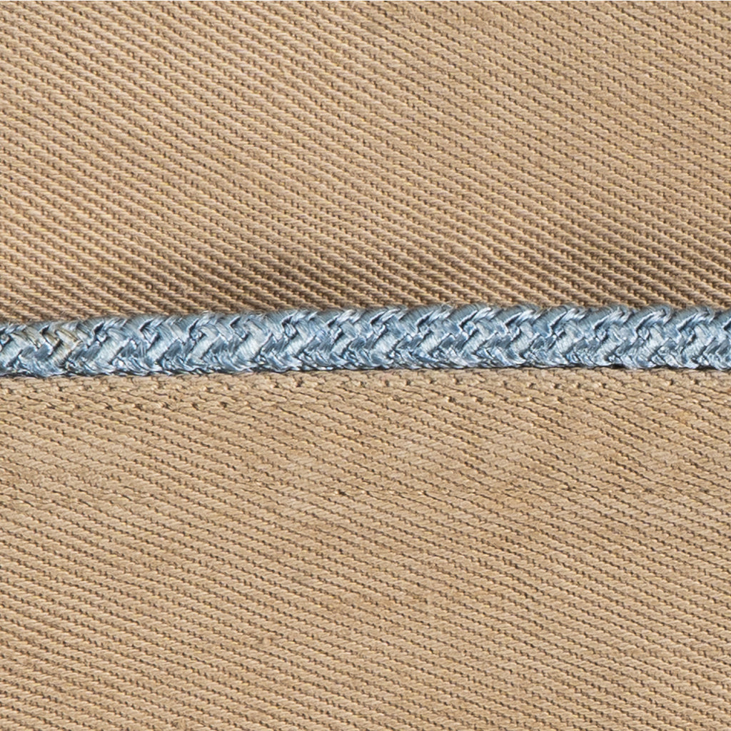 Macro detail of a vintage Khaki Garrison Cap featuring blue braided piping against tan cotton twill fabric.