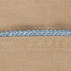 Macro detail of a vintage Khaki Garrison Cap featuring blue braided piping against tan cotton twill fabric.