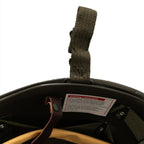 Interior detail of the M1 style helmet featuring a safety warning label on the plastic liner.