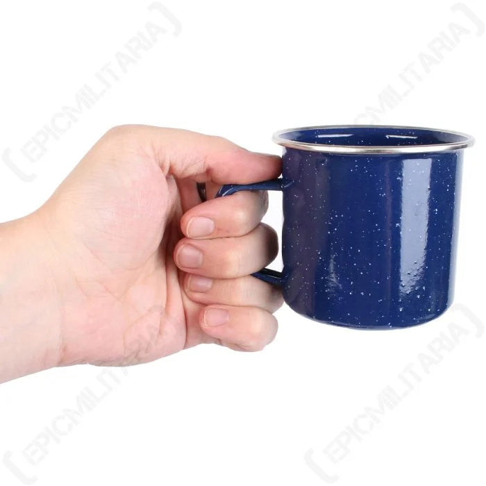 Close-up of blue enamel camp mug held in hand showing handle and stainless steel rim.