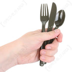 Close up of olive drab plastic camping fork knife and spoon held in hand