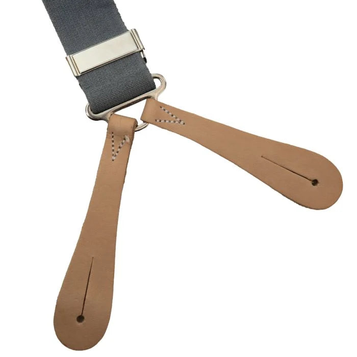 Close-up of the tan leather trouser button attachment loops and metal slider buckle on a grey military brace