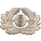 Rear view of East German NVA officer visor cap badge showing flat dual metal attachment prongs