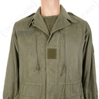 Close-up of the French M64 field jacket chest, displaying vertical zippered pockets and central hook and loop patch for military insignia.