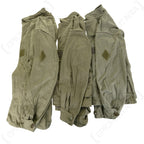 Three original French M64 field jackets stacked to show arm detail, including the Armée Française stamps and hook and loop sleeve patches.