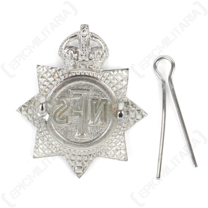 Rear view of National Fire Service cap badge with split pin detached showing copper attachment loops