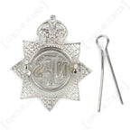 Rear view of National Fire Service cap badge with split pin detached showing copper attachment loops