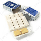 Unpacked Seven Oceans survival ration featuring grease-proof wrapped bars, one open foil pouch, and two exposed compressed food biscuit squares.