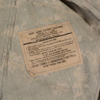 Close-up of a specific Army Combat Uniform care label detailing washing and maintenance instructions for nylon cotton ripstop.