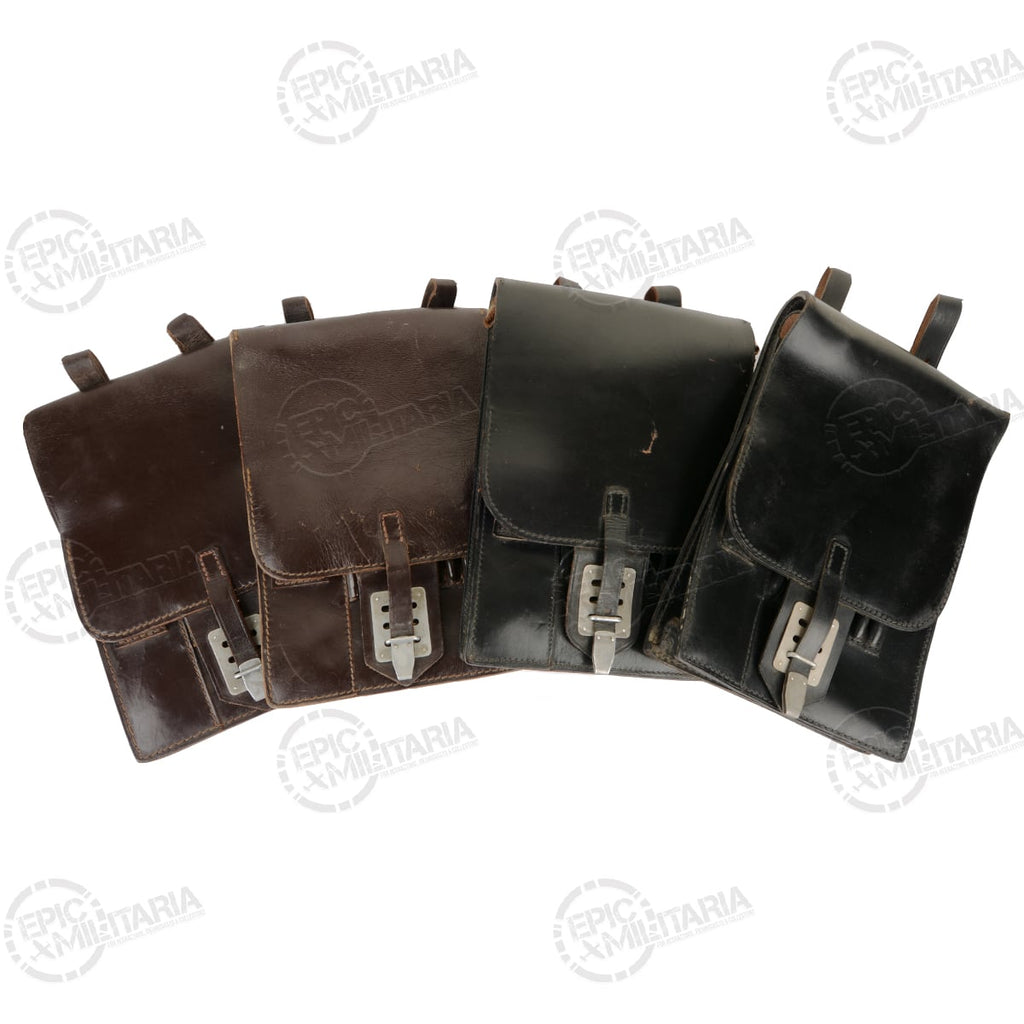 A collection of four original Austrian Army leather map cases, displaying variations in brown and black leather finishes.