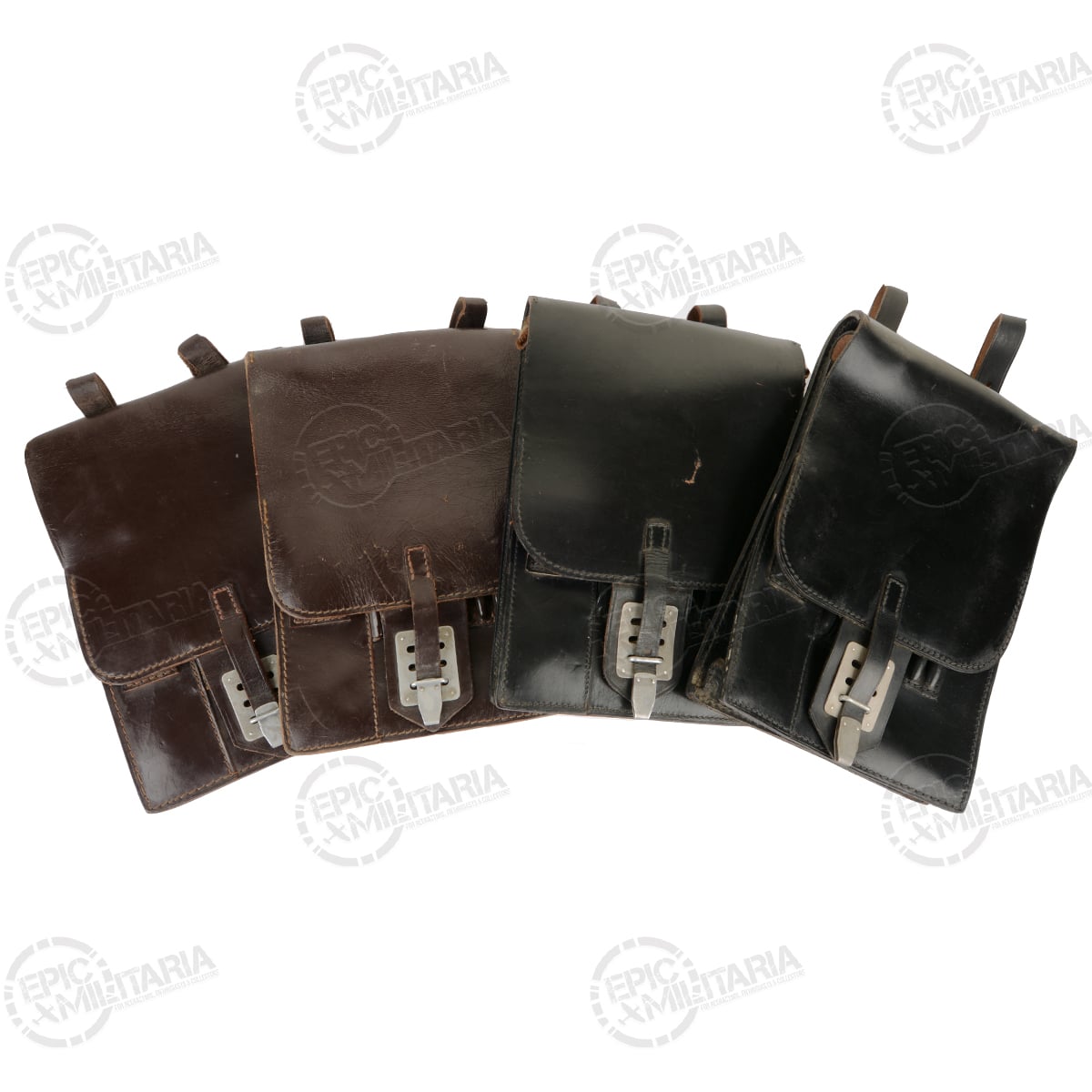 A collection of four original Austrian Army leather map cases, displaying variations in brown and black leather finishes.