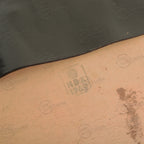 Close-up detail of internal markings stamped HB 1960 on the light-colored lining of a vintage black leather map case.