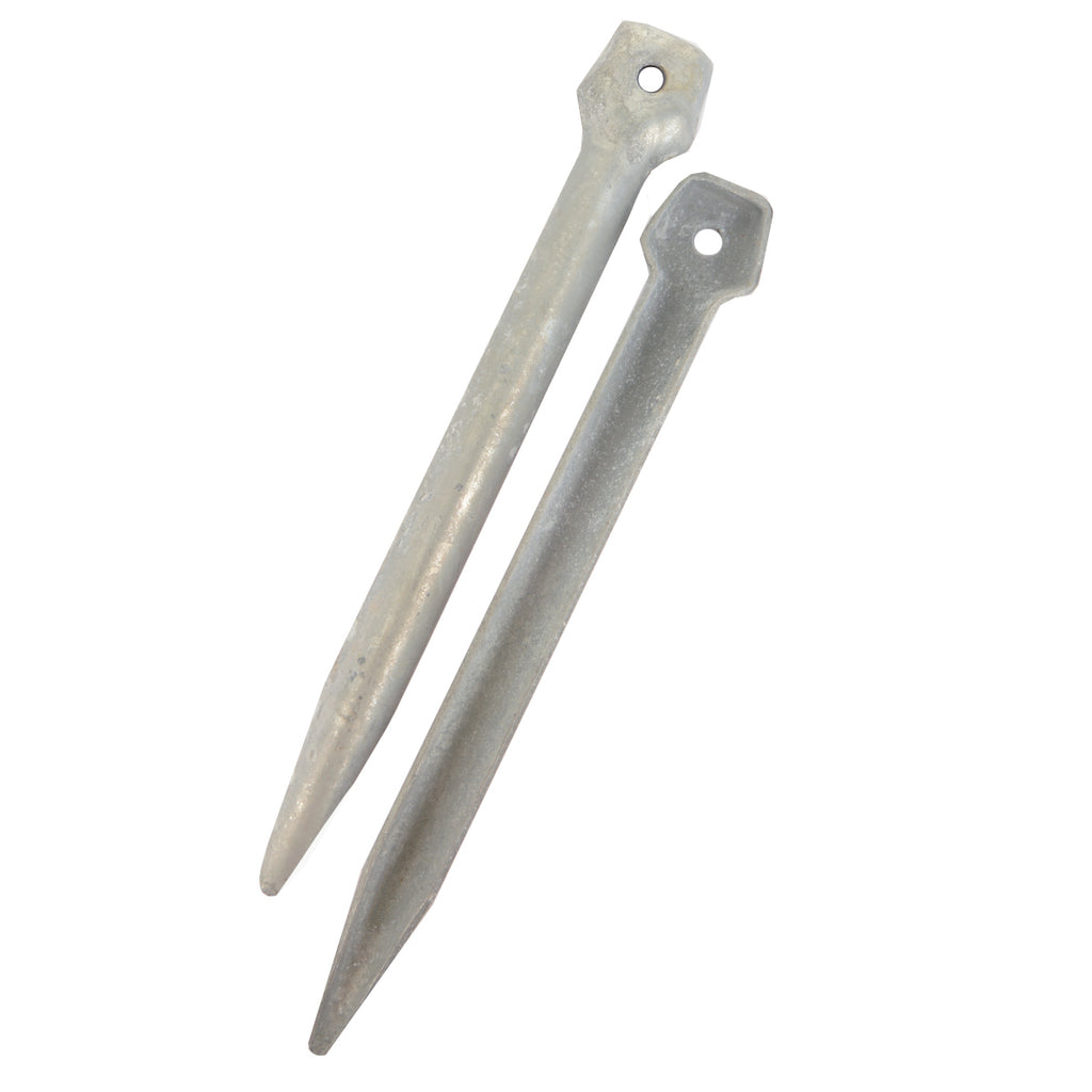 Two original iron tent pegs angled side by side, featuring pointed tips and securing holes for guy ropes, isolated on a white background.