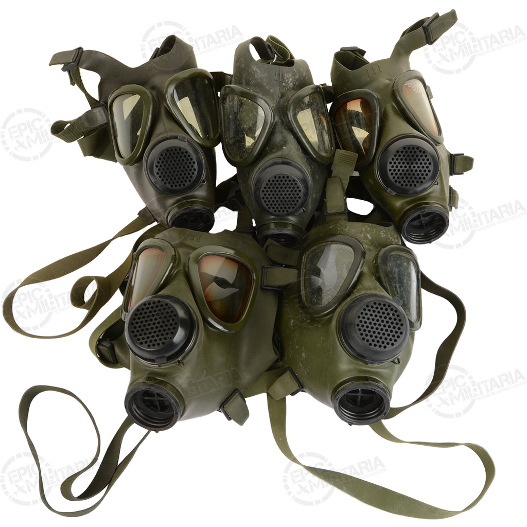 A collection of five original Romanian Army M74 gas masks, highlighting the variations in lens condition for this military surplus gear.