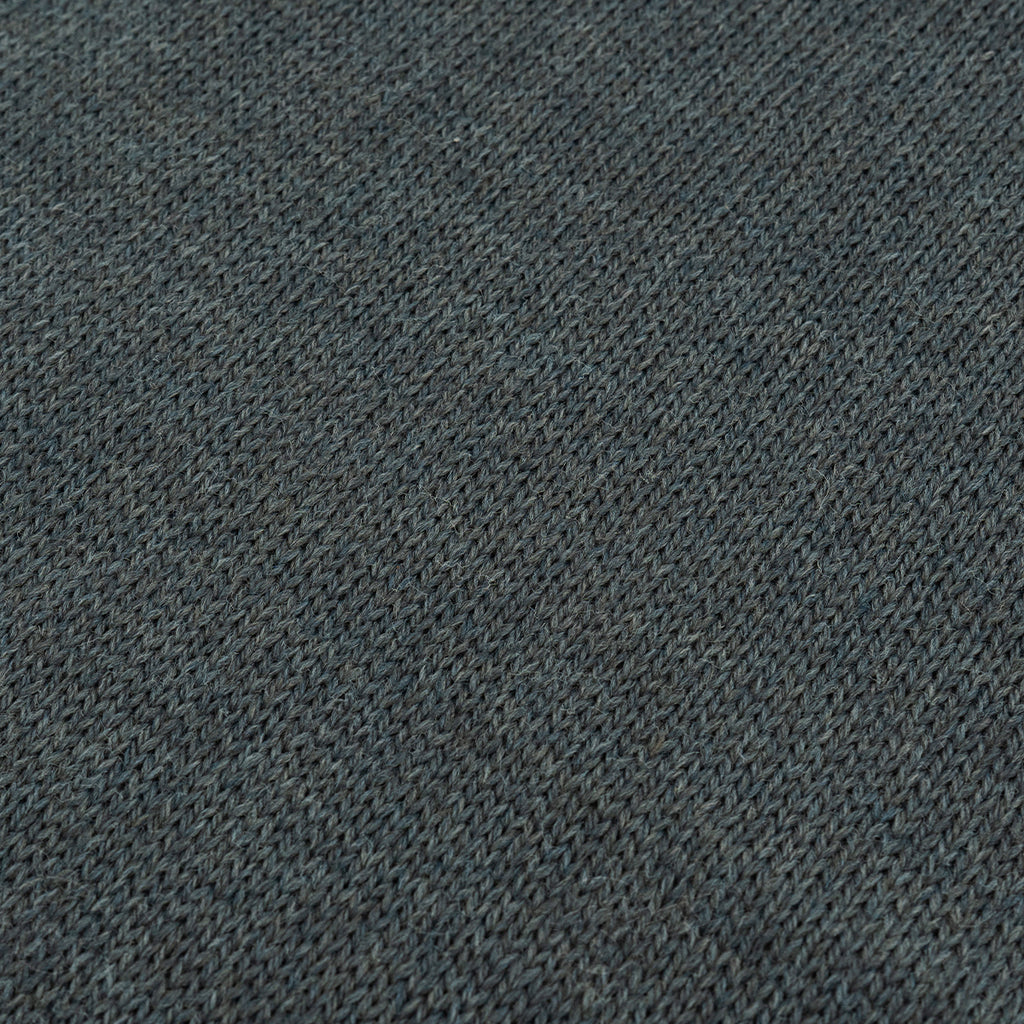 Close-up of the grey wool fabric texture illustrating the double-layered knit insulation of the Swedish military scarf.