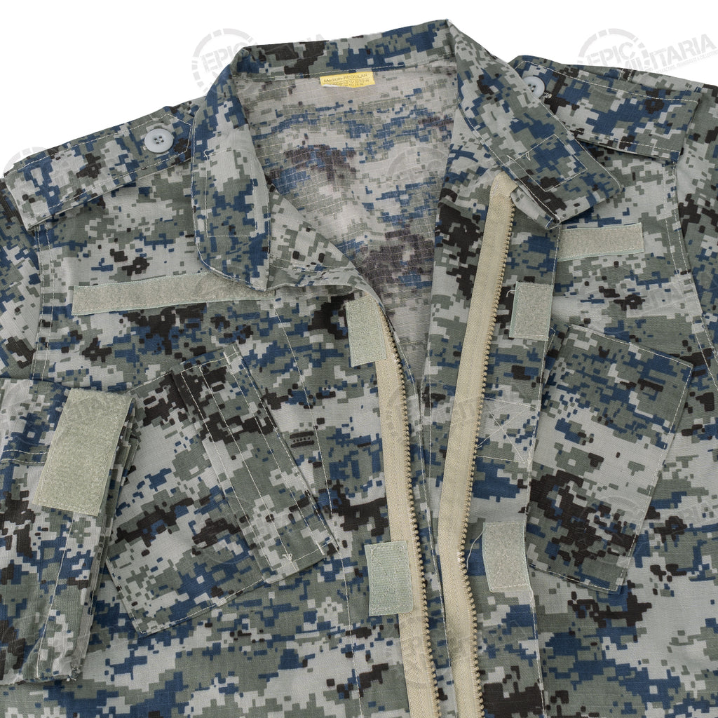 Close-up of the shirt interior, showing the open zipper, hook and loop fasteners on pockets, and the size tag detail.