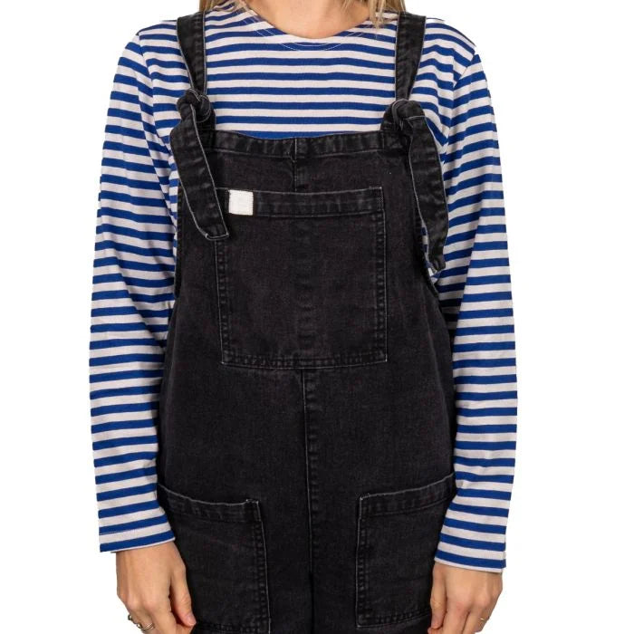 Female model styling striped Russian Telnyashka shirt under black denim dungarees