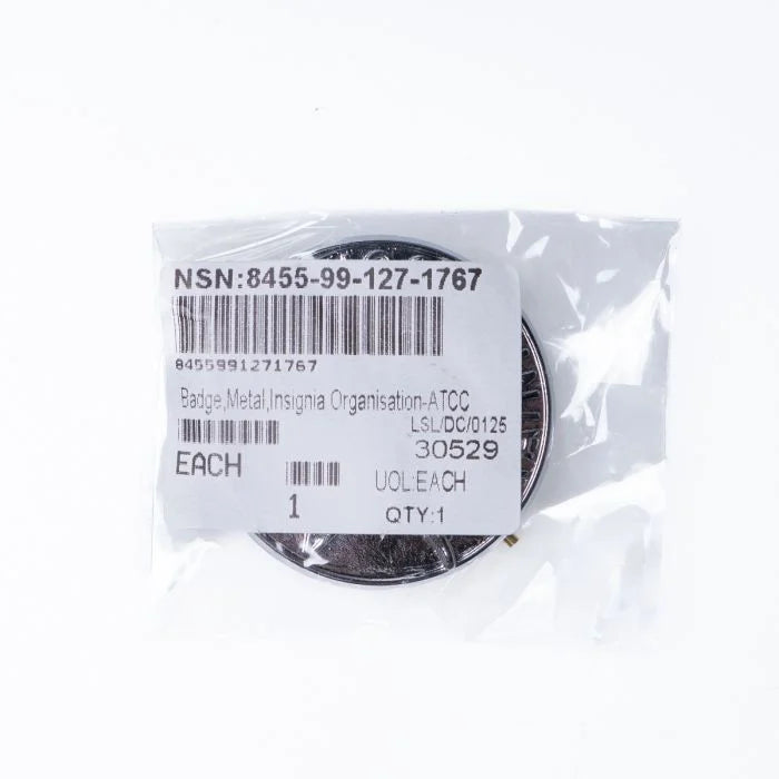 Unissued British military surplus ATC cap badge sealed in original plastic packaging with NSN label 8455-99-127-1767