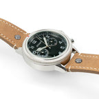 Angled side perspective showing the fluted timing bezel, red marker, and pushers on the pilot watch
