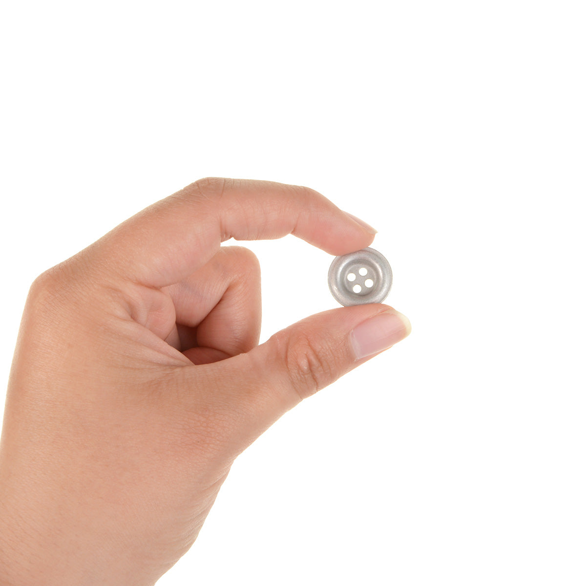 A person holding a single 18mm silver metal dish button between their thumb and index finger to demonstrate the small, versatile scale.