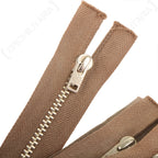 Macro detail of a Kynhook Lightning zipper pull showing metal construction and the herringbone weave pattern on the tape.
