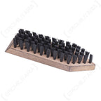Close-up perspective of an unused Bundeswehr shoe brush highlighting the dense arrangement of stiff black bristles on a wooden base.
