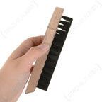 A hand holding an original German Army shoe brush showing its ergonomic wooden handle and durable design for footwear maintenance.