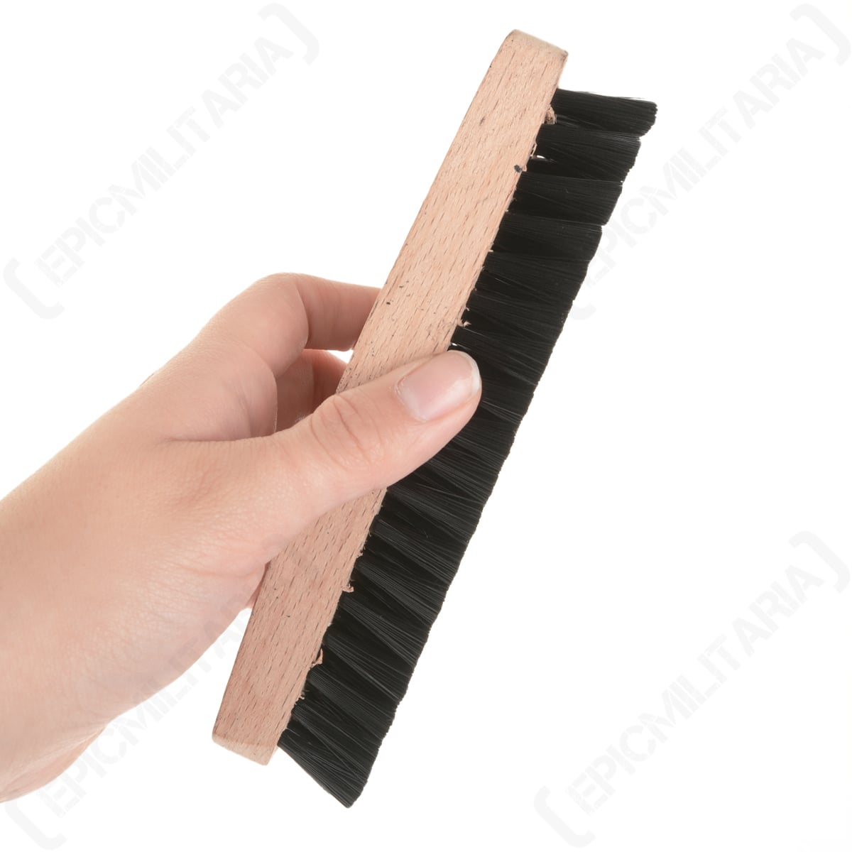 A hand holding the compact German Army clothes brush, showcasing its ergonomic wooden grip and size for cleaning military apparel.